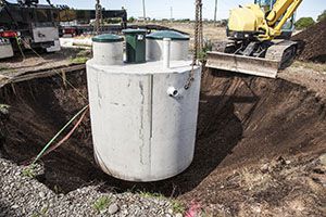 Environmentally friendly septic tank being lowered into ground.